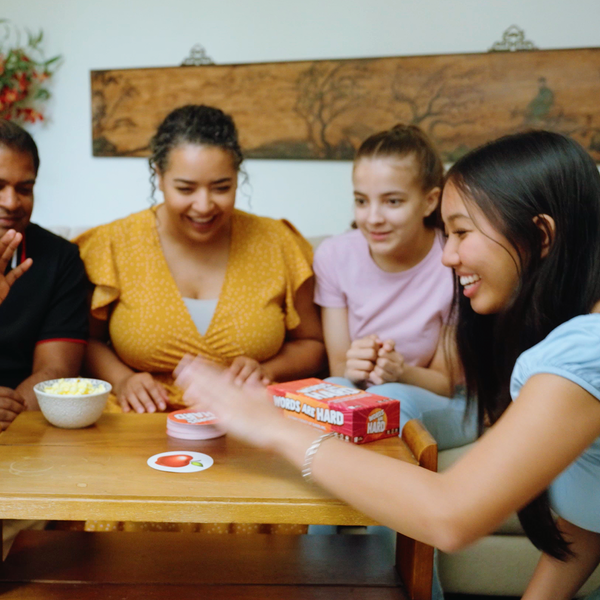 Group of people gathered around a table with text overlay 'IN ALMOST EVERY HOUSEHOLD!'